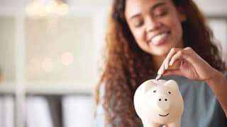 gettyimages young woman save piggy bank.jpeg