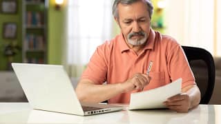 mature person holding pen and looking at document.jpg