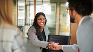 smiling businessperson shaking hands with someone.jpg