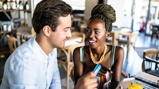 Couple has card out to pay in a restaurant. u.width .jpg