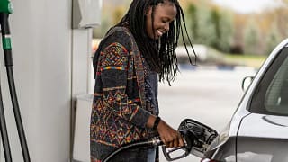 Person smiling while pumping fuel into vehicl.width .jpg