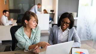 Two women looking at charts on tablet and lap.width sZnkNAm.jpg