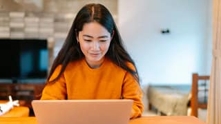 Young woman looks at laptop at home CYjw.width .jpg