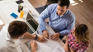 man and woman sitting across desk from man in.width leqlGi.jpg