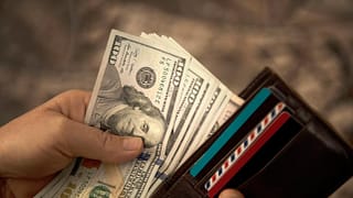 person placing hundred dollar bills into a wallet.jpg