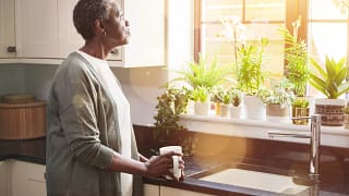 person standing in a kitchen looking out a window.jpg