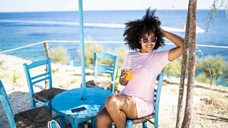 person with drink at table with tropical ocea.width .jpg