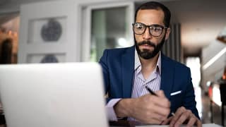 serious person staring at laptop and writing note.jpg