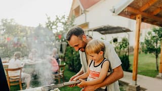 Father and son grill corn during a cookout on.width .jpg