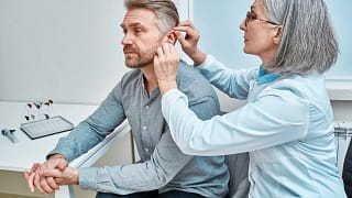 Mature person being fitted for hearing aids. .width .jpg