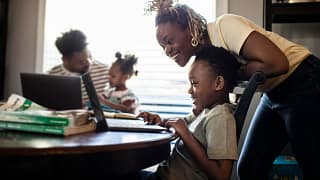 Mother helping young child with e learning on.width jYiYcn.jpg