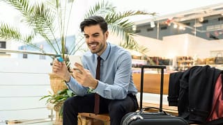 Traveler at airport with luggage phone and cr.width .jpg