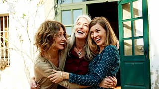 Two middle aged people hug an older matriarch.width .jpg