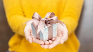 Woman holding small gift BHDbAvx.width .jpg