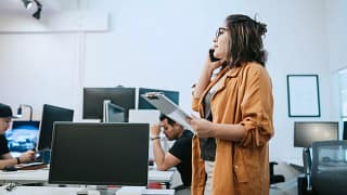 Woman in office holding clipboard and talking.width imFW.jpg