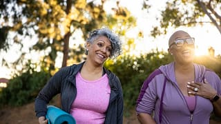 two middle age adults outdoors with yoga mats.width TkHNuQw.jpg