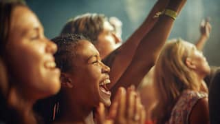 People in a crowd enjoying some form of live .width .jpg