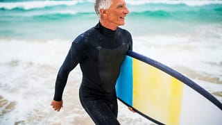 Person in wet suit carrying surf board in fro.width .jpg