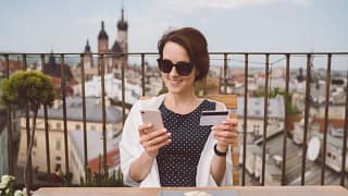 Woman holding her credit card and smiling whi.width iMSYz.jpg