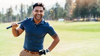 getty smiling golfer on course blue shirt.jpg