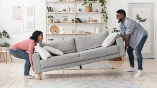 man and woman moving couch in living room MHH.width .jpg