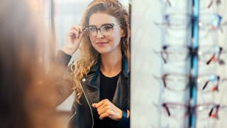 Smiling young woman trying on eyeglasses. dg.width .jpg