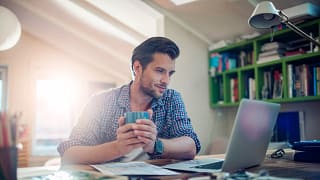 man s laptop holding mug gettyimages .jpg
