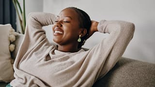 relaxed person sitting on couch with hands behind head.jpg