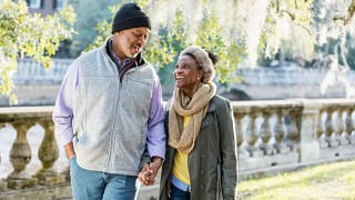 two older people walking in the park holding handds.jpg