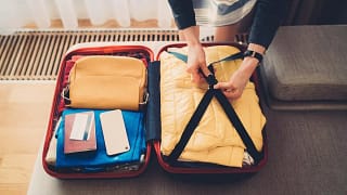 woman packing suitcase with credit card on to.width guLi.jpg