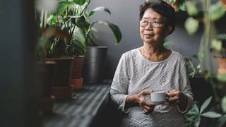 woman drinking tea near houseplants rpwlRul.width .jpg