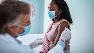 Masked woman receiving injection in her arm A.width .jpg