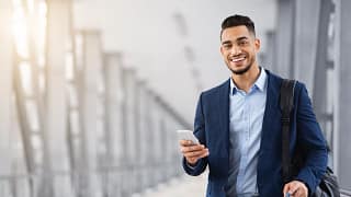 getty business traveler with shoulder bag smiling happy.jpg