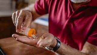 older man pouring pills into hand gettyimages .jpg