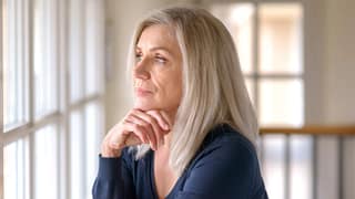 older person with serious expression looking out a window.jpg