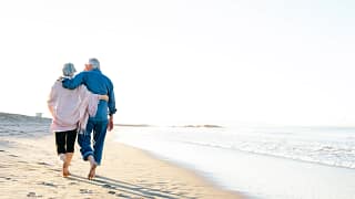 two older people walking on the beach.jpg