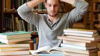 Male college student stressed books library S.width .jpg
