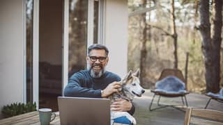 older man at laptop with dog gettyimages .jpg