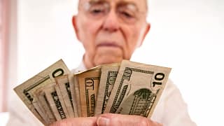 senior holding assortment cash bills social security retire getty.jpg