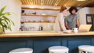 two people standing at kitchen counter looking at a computer.jpg