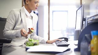 woman eating salad at work rCJmRBb.width .jpg