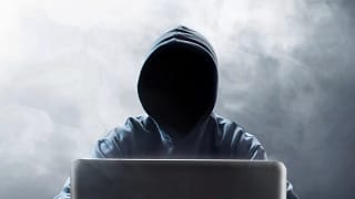 Hooded figure at laptop EBPOVYO.width .jpg