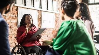 businessperson in wheelchair leading team meeting.jpg