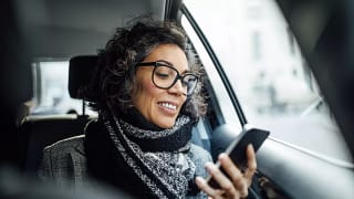 person sitting in a car looking at a phone.jpg
