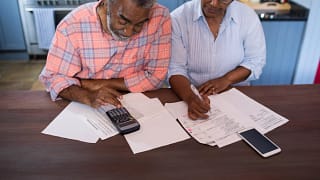 two people looking at documents and a calculator.jpg