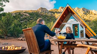 couple toasting over table outside house.jpg