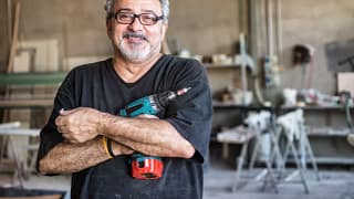 getty smiling happy workers with tool drill blue collar.jpg