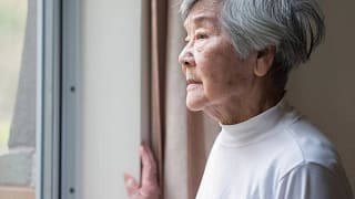 senior woman looking outside care facility.jpg