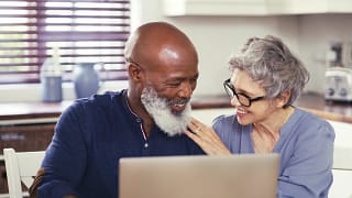 smiling mature couple using laptop at home.jpg