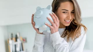 smiling person shaking piggy bank.jpg